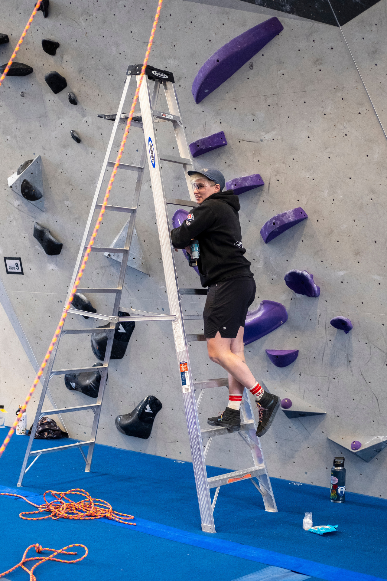 Nat Vorel routesetting on a ladder
