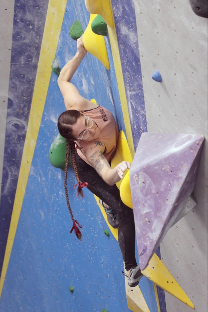 Mia working on a bouldering problem