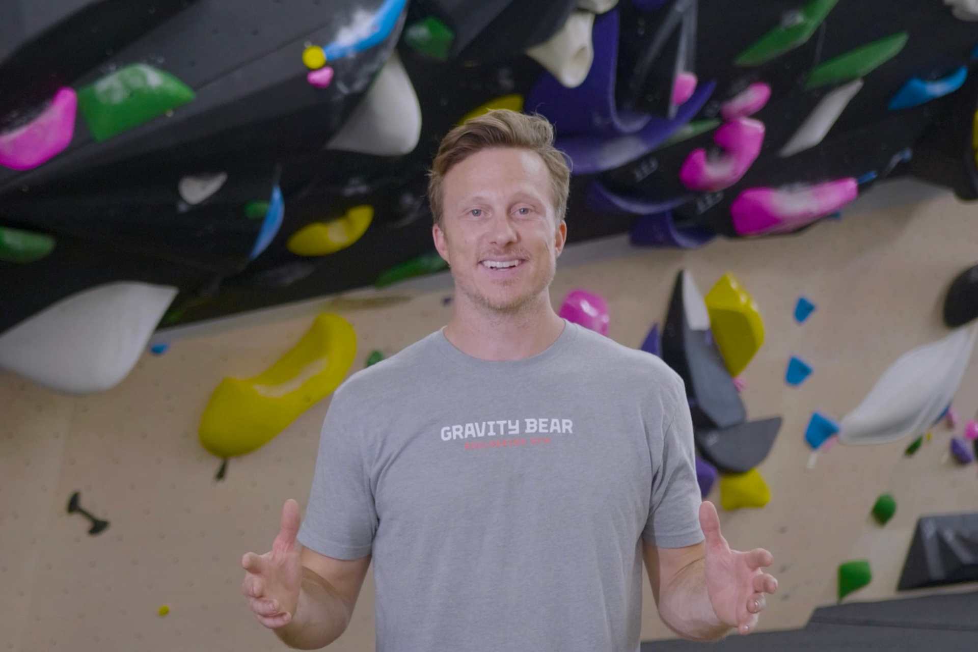 Parker Simms in front of a climbing wall at Gravity Bear