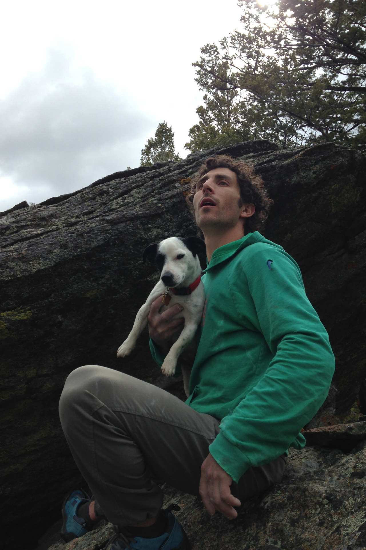 Mike sitting in front of a boulder with his dog
