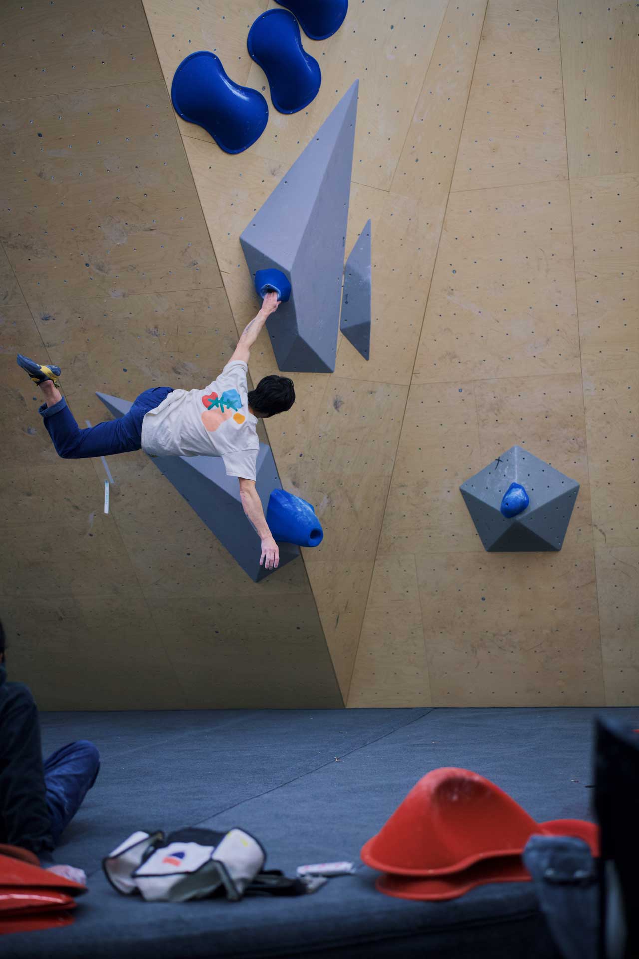 A boulderer sticks the move to a pocket on a volume