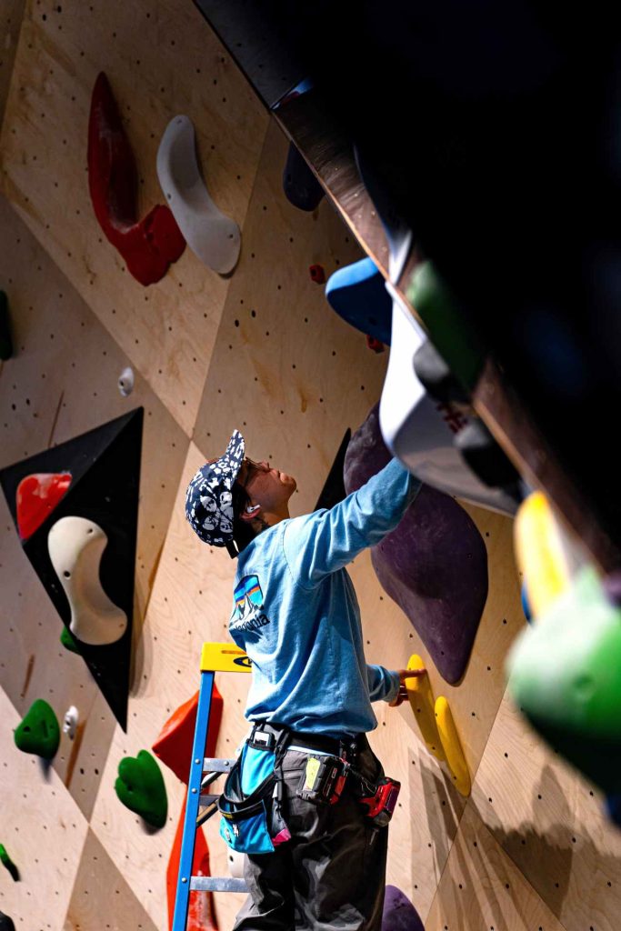 Zuoyi setting a bouldering problem in the gym