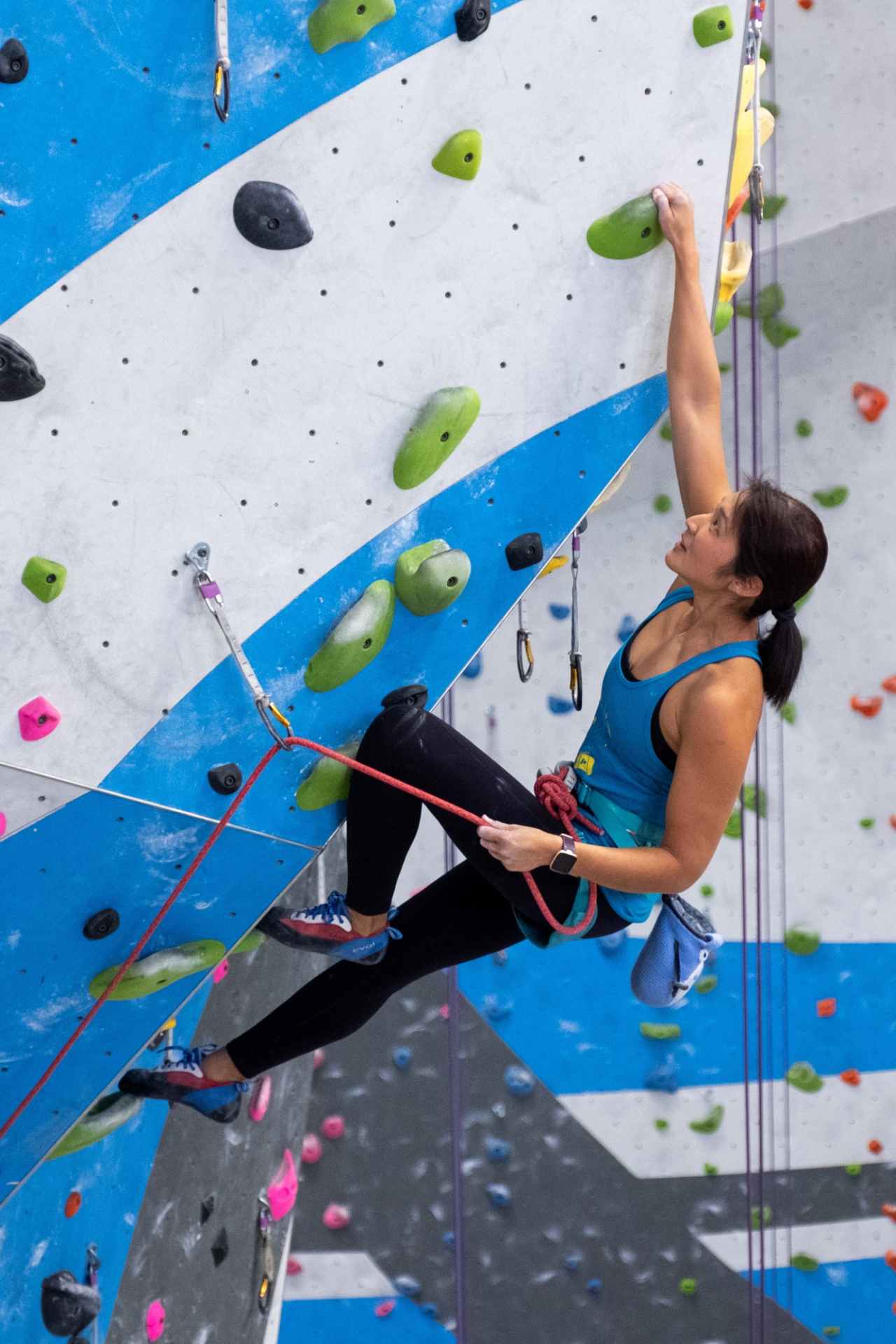 Another photo of Alice lead climbing indoors