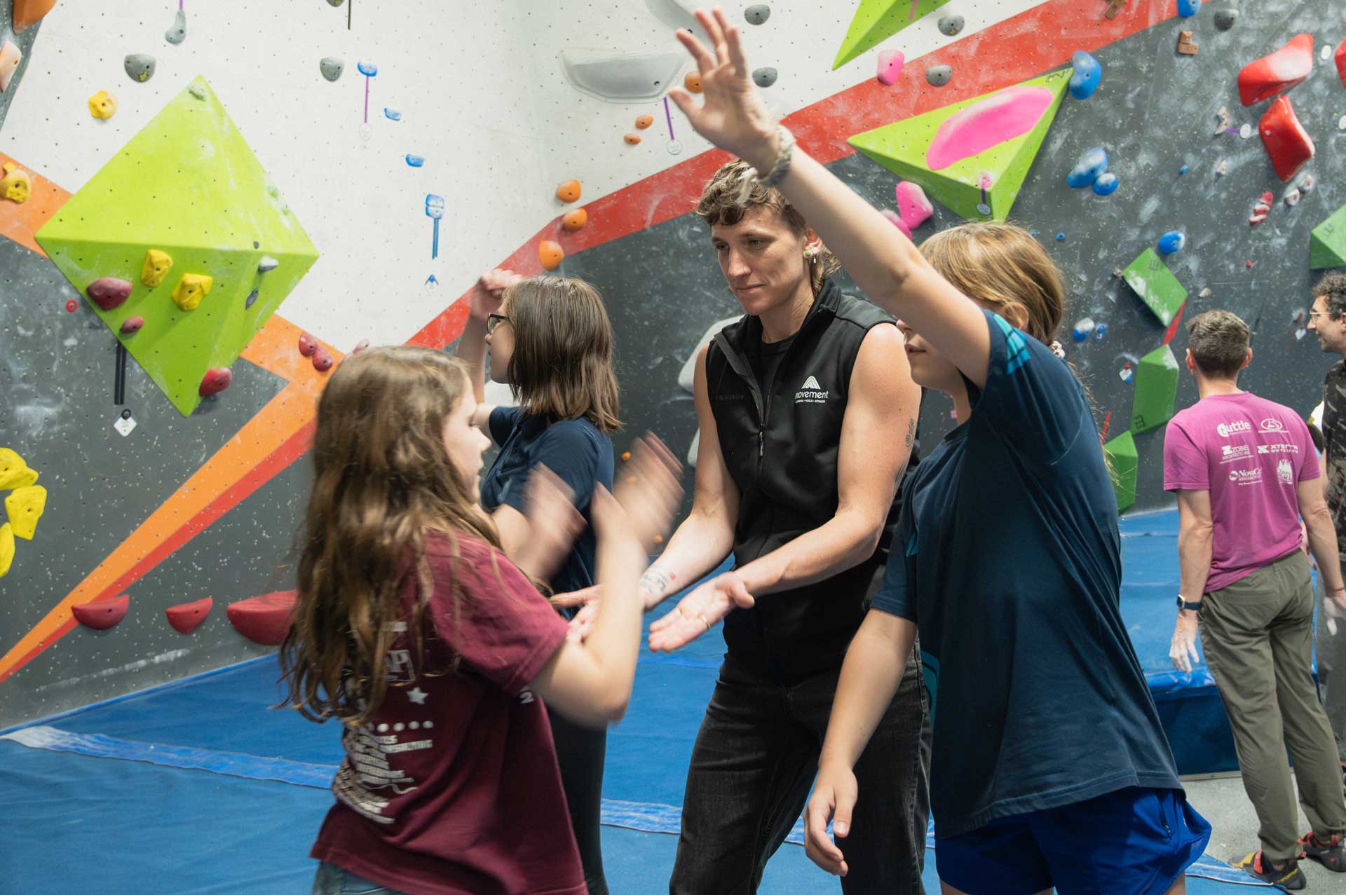 Smiley working with a group of youth climbers in the gym