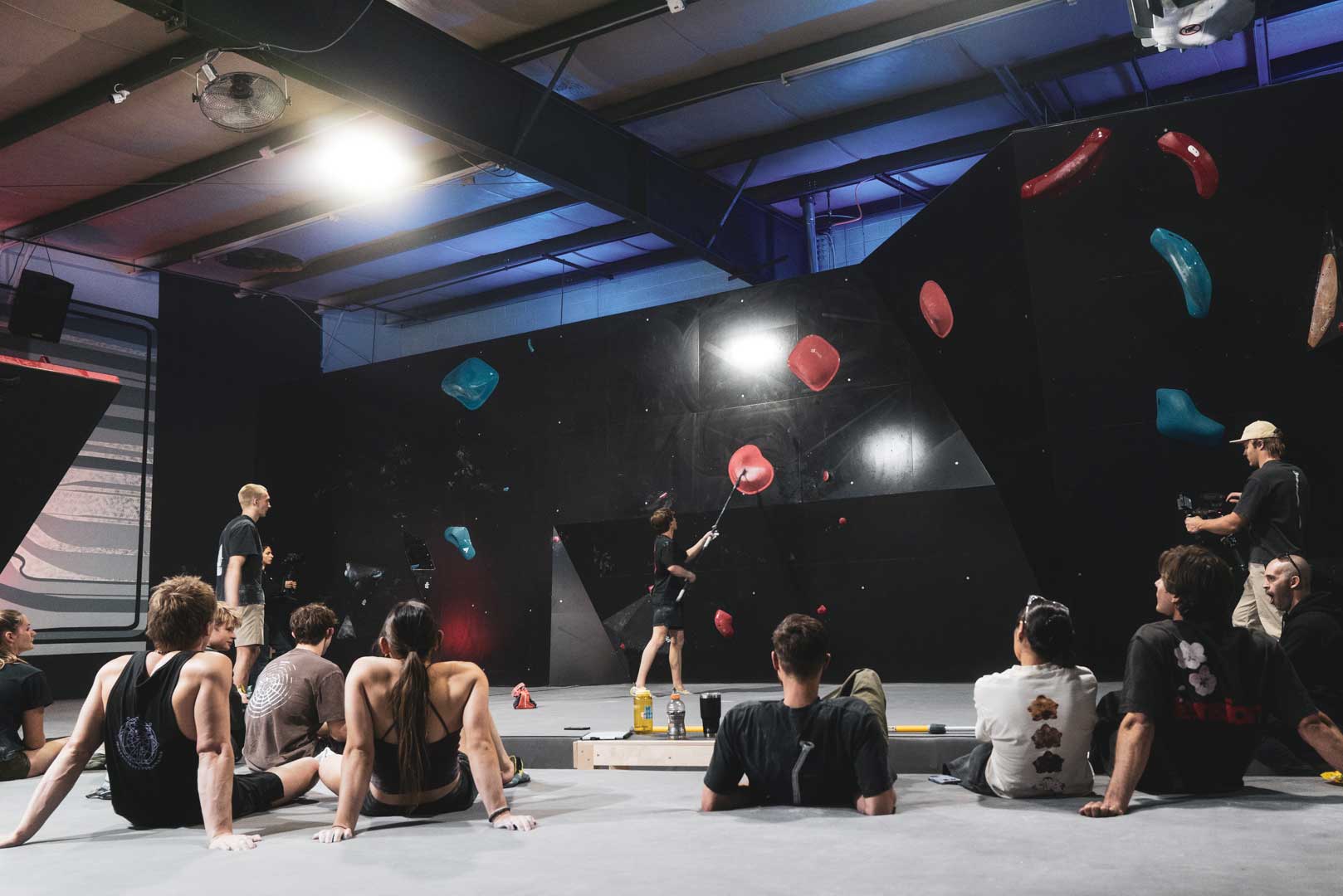 Athletes sitting in front of another bouldering wall at the TTC