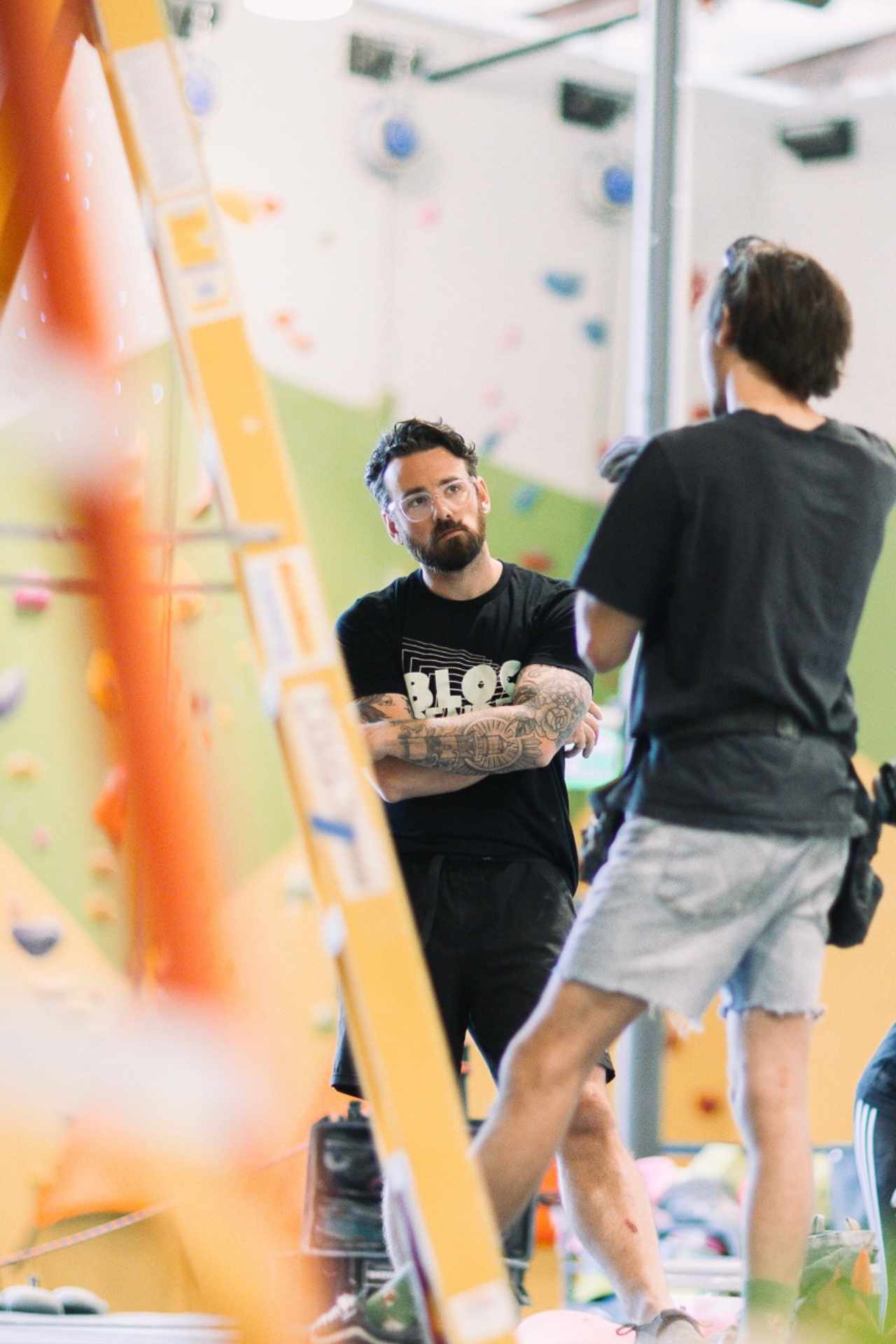 Kenny Benson talking to a fellow routesetter in the gym