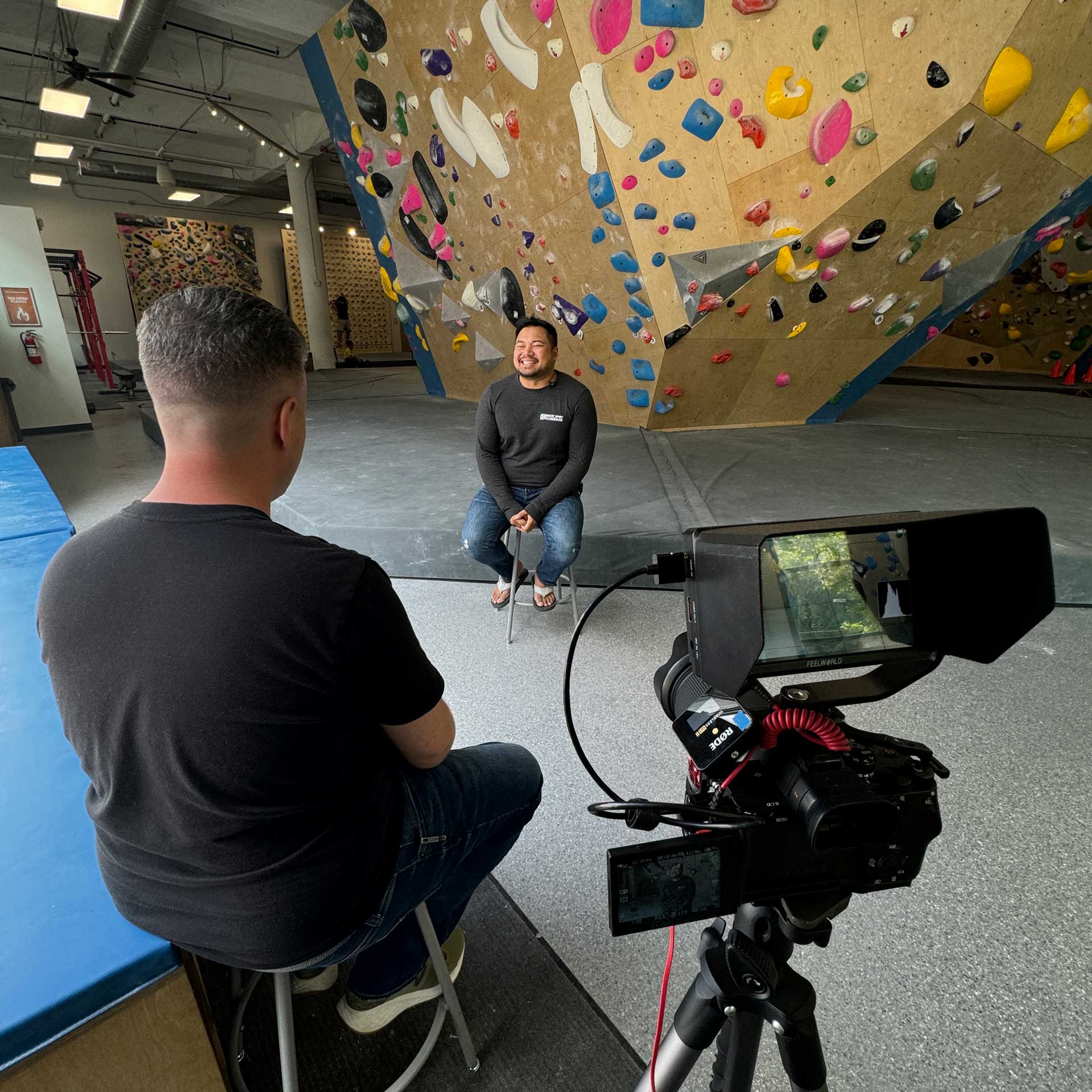 Clay conducting a video interview in the gym
