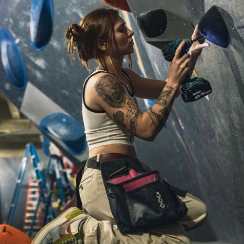 Annebelle drilling a hold into a bouldering wall