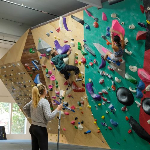 Claire Gordon coaching at a climbing gym